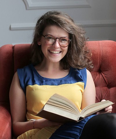 woman in blue and yellow dress sitting on red sofa